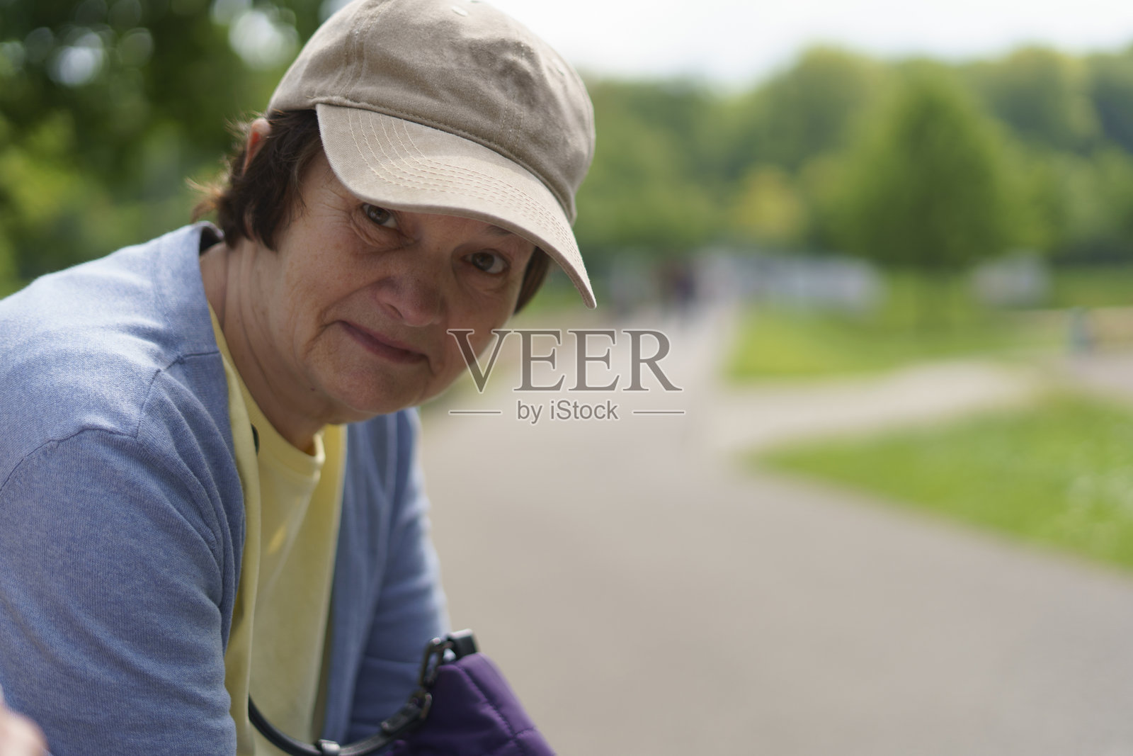 积极的老年女性穿着毛衣，在夏天的公园里。活跃健康的退休生活理念。照片摄影图片