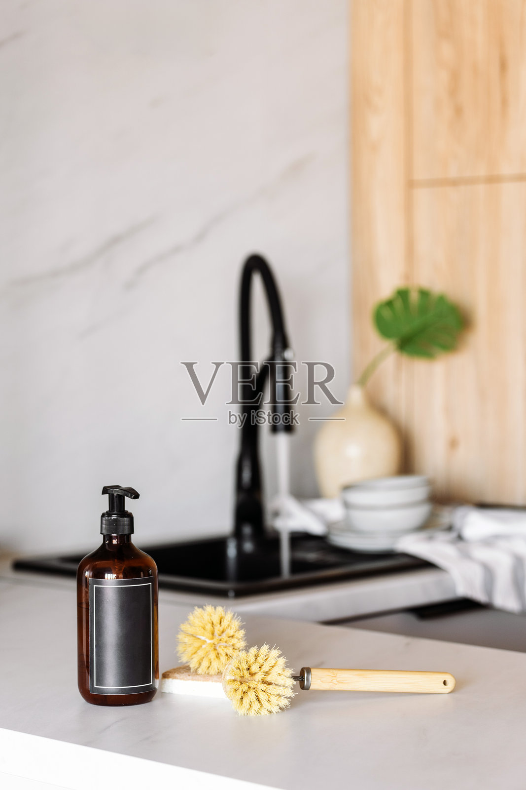 现代厨房水槽配有黑色水龙头和时尚的清洁用品在台面上照片摄影图片