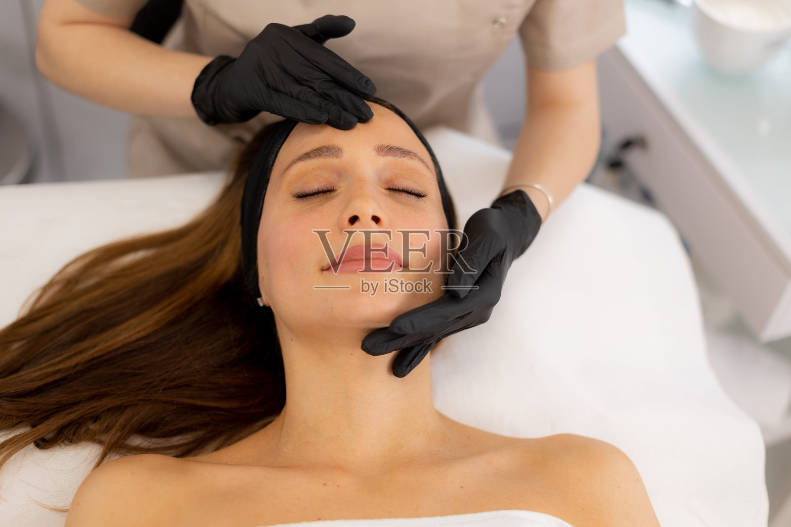 在宁静的水疗中心享受舒缓面部护理时的放松与焕发活力，沐浴在午后的阳光中照片摄影图片