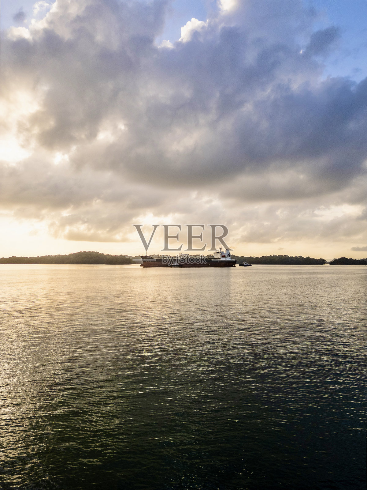 巴拿马运河中的帆船停泊，背景是货船。照片摄影图片