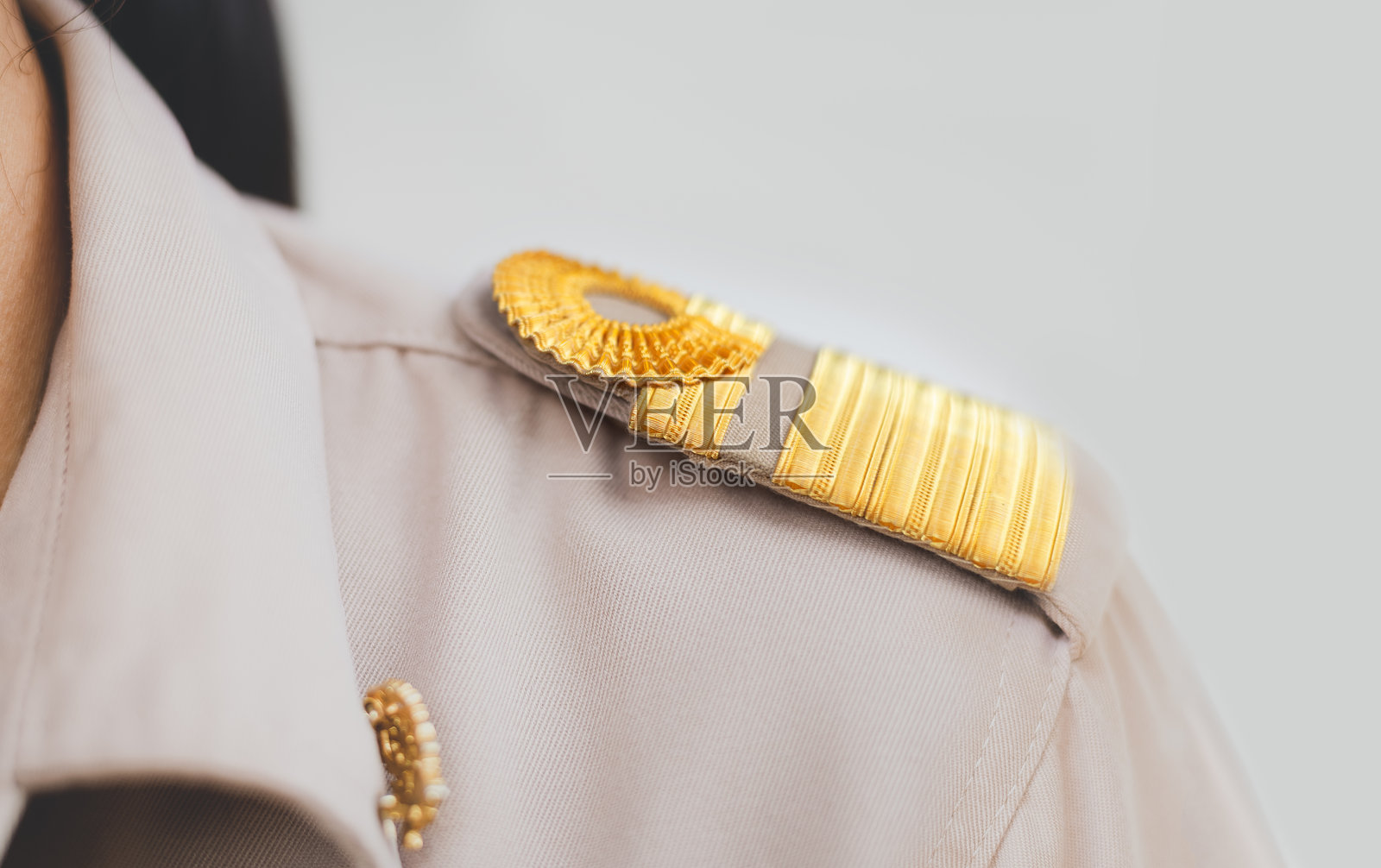 穿着棕色西装和肩部金色条纹的女泰国教师在学校里，泰国教育照片摄影图片