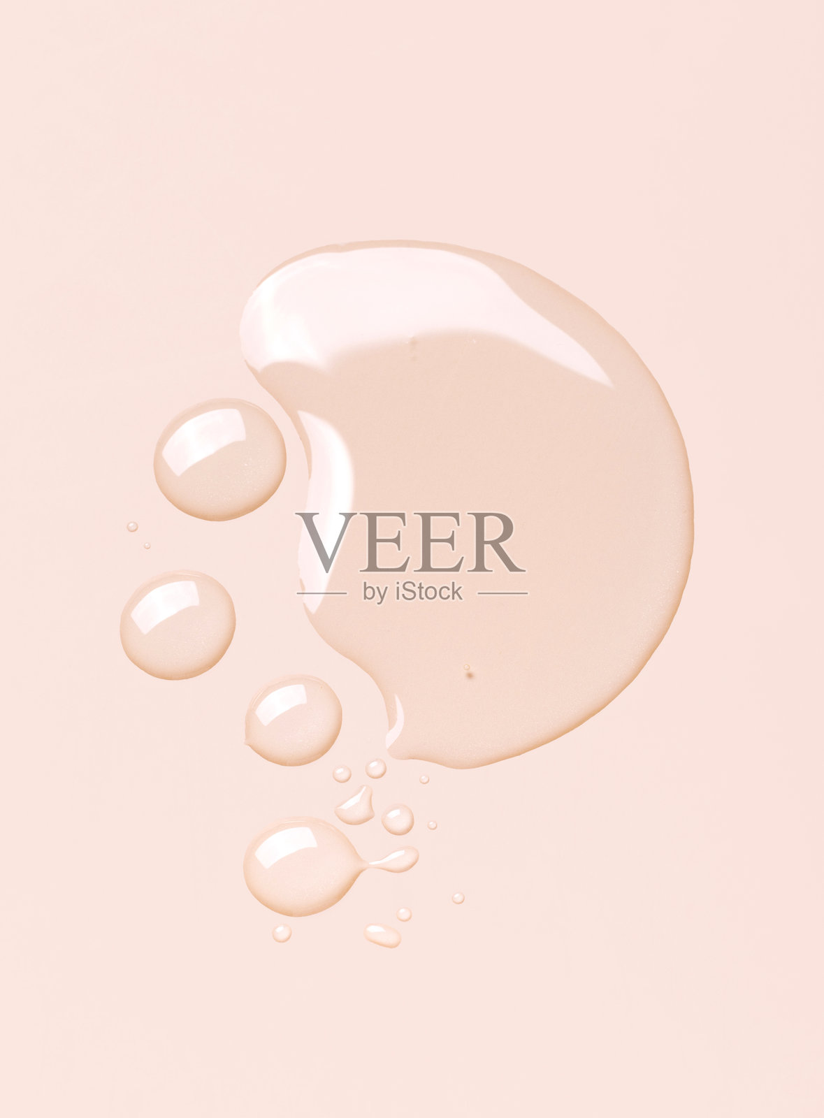 米色背景上的透明凝胶精华圆滴照片摄影图片