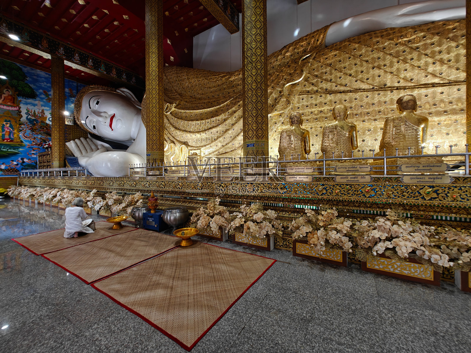 寺庙内的大型卧佛与身穿白色裙子的游客照片摄影图片