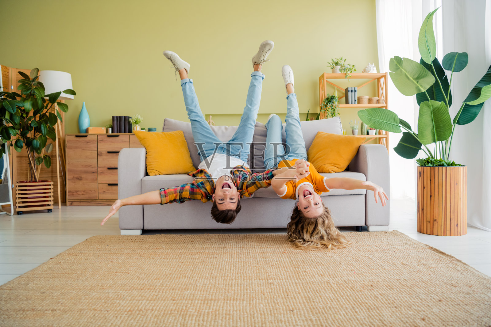 年轻情侣在现代明亮的春季舒适室内公寓里，倒着躺在沙发上享受时光的全身照片照片摄影图片