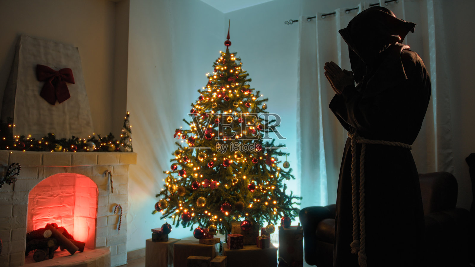 孤独的宗教僧侣在圣诞树前祈祷的剪影照片摄影图片
