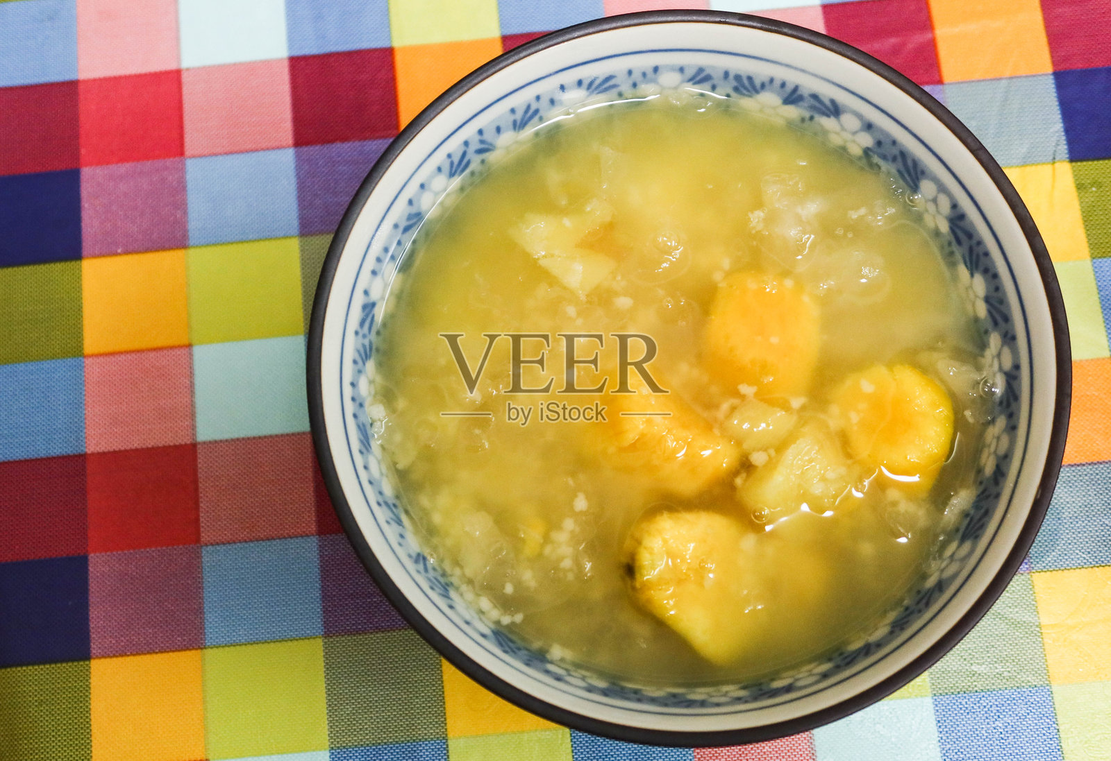 自制热腾腾的中国黄甜薯甜汤，碗中加入薏米，留有空白空间。照片摄影图片