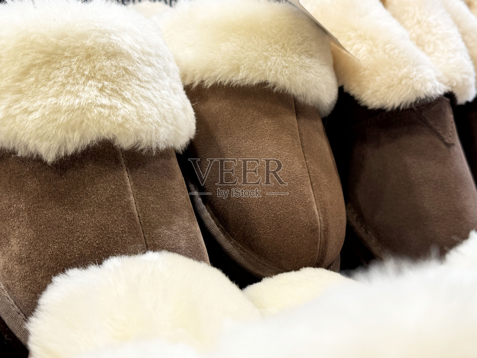 舒适的棕色绒面羊皮拖鞋，内衬柔软的白色羊毛，特写镜头照片摄影图片