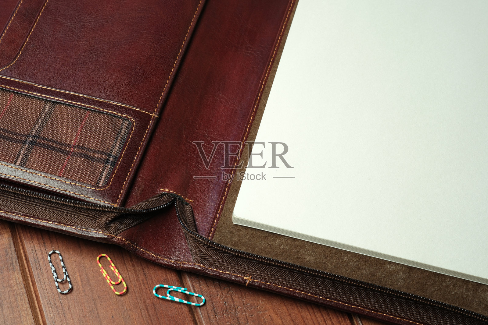 优雅的皮革活页夹，内有空白页和五彩纸夹，放在木桌上照片摄影图片