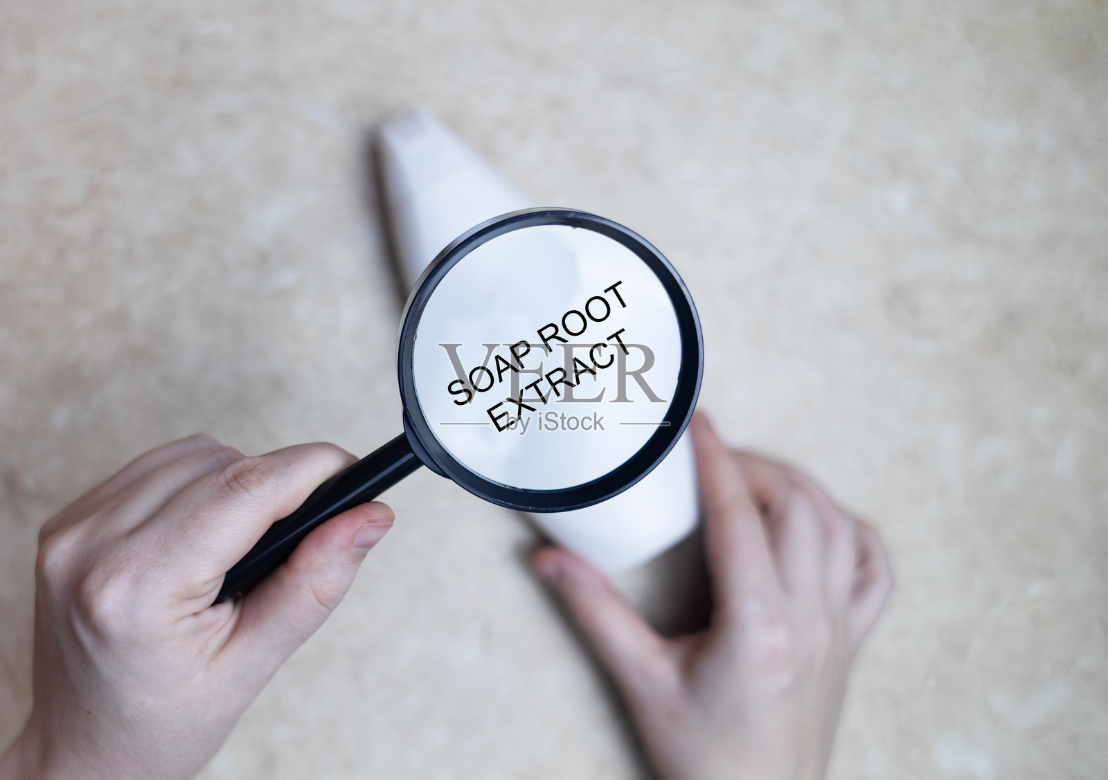 女性手握着一瓶洗发水，瓶身上写着成分 - 肥皂根提取物。安全有机洗发水成分的概念。照片摄影图片