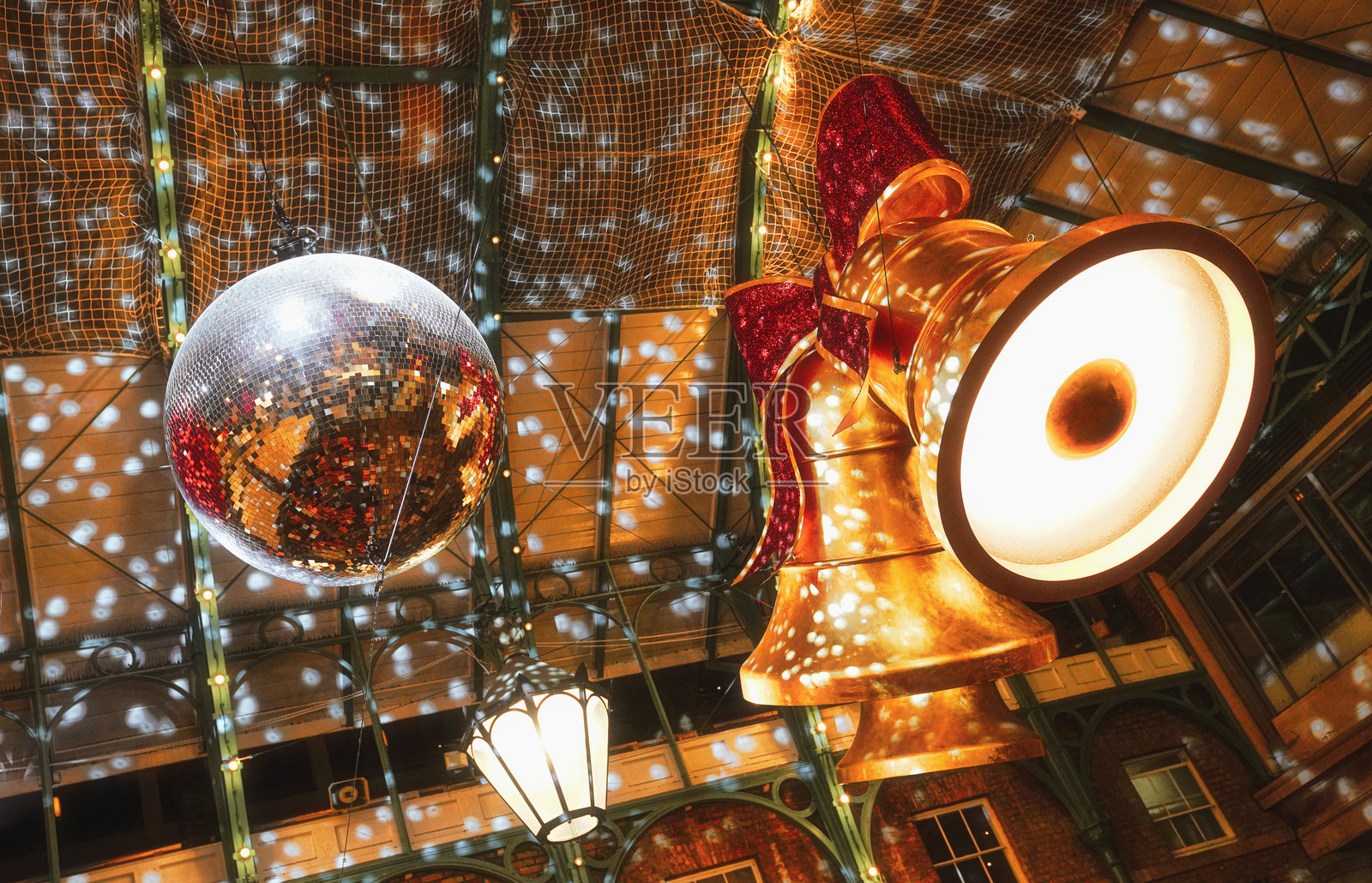 考文特花园广场巨大的圣诞铃铛，配有红色蝴蝶结和旋转的镜面球照片摄影图片