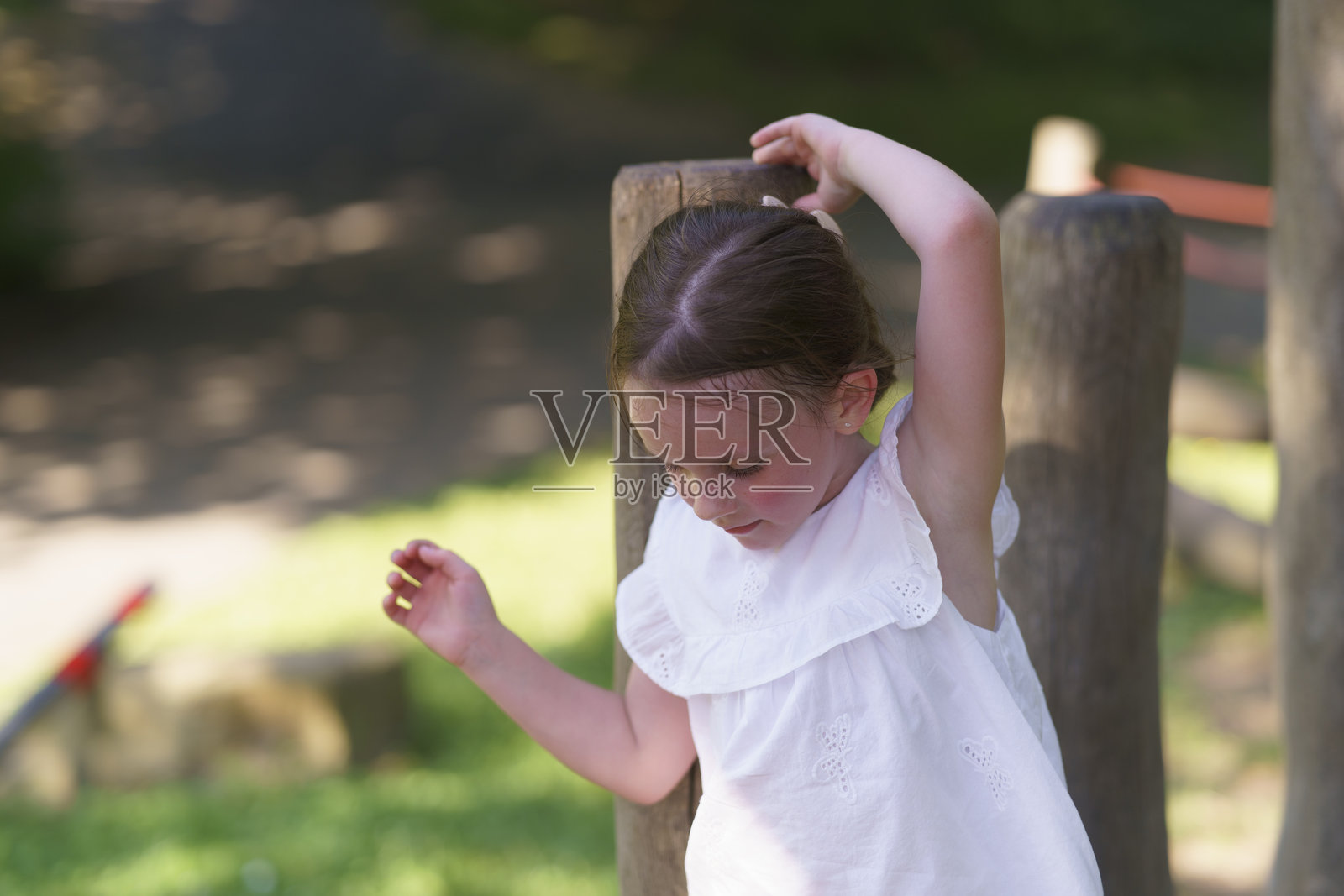 可爱的小女孩没有前牙，在夏季公园的绳索游乐场玩耍。活泼健康快乐儿童的概念。照片摄影图片