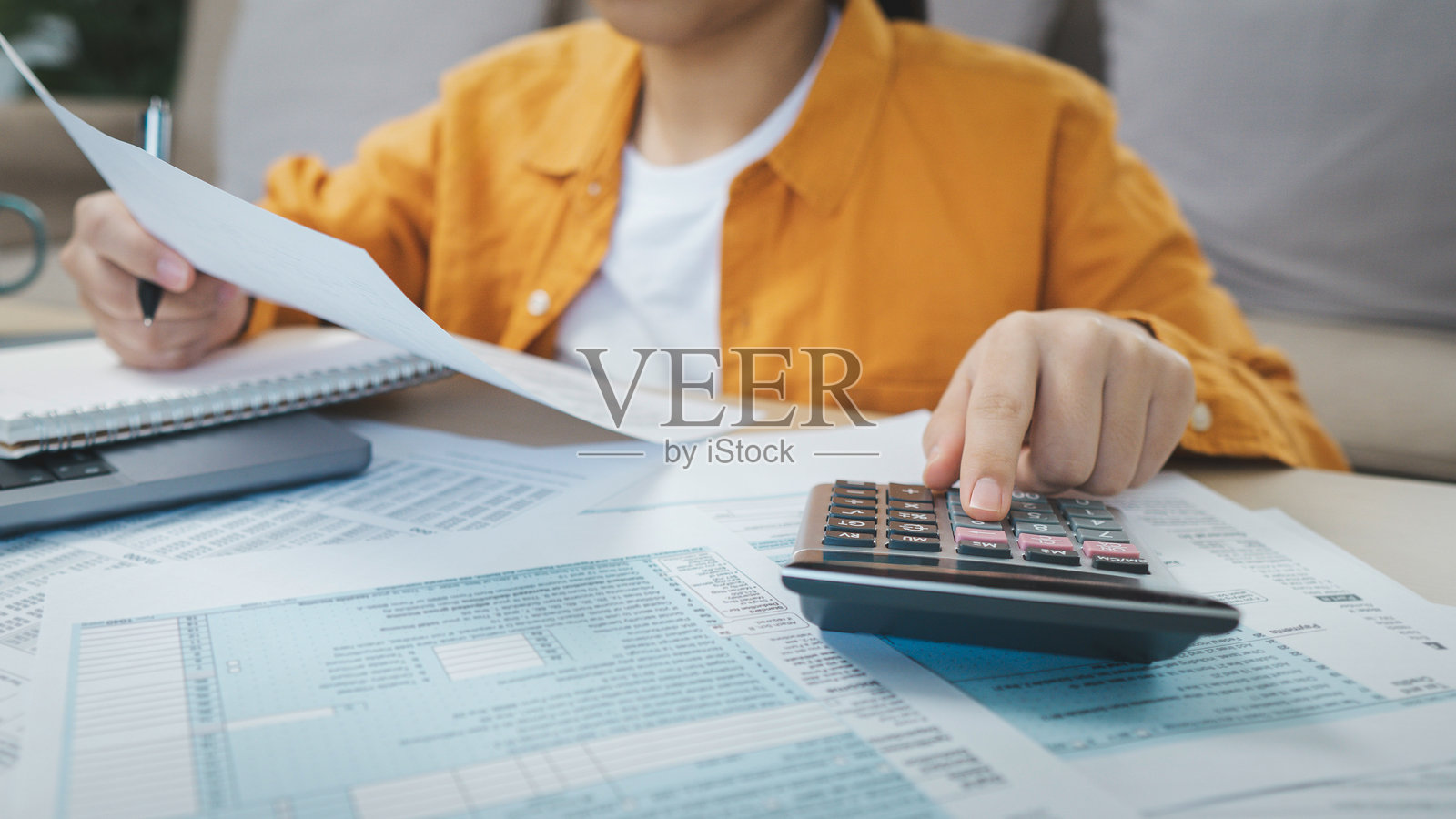 税务申报准备和财务管理的概念。商人在使用计算器和笔记本电脑计算税款。财务、所得税、税务文件和储蓄。照片摄影图片