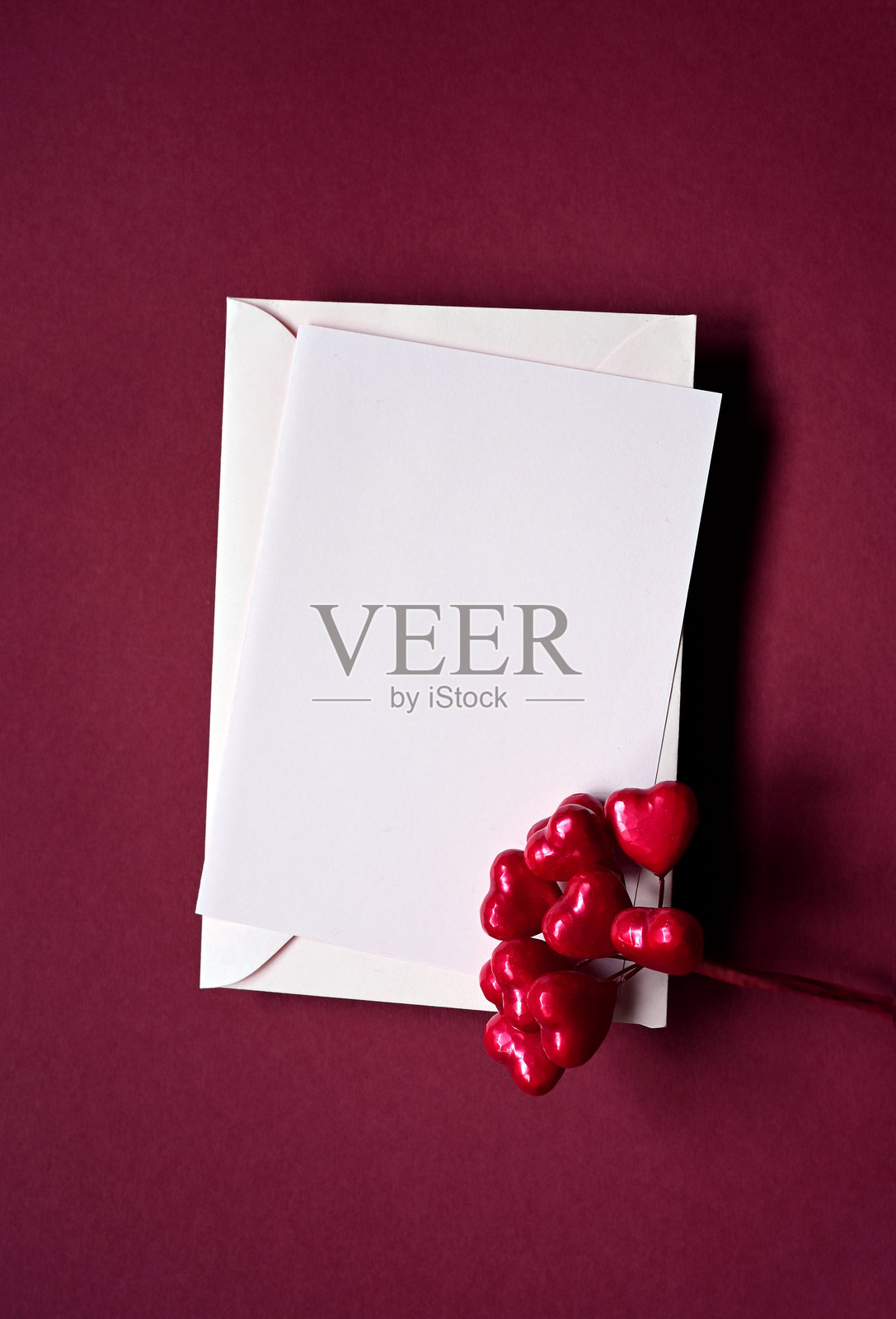 红色背景上的信封和红色心形图案。俯视图。情人节照片摄影图片