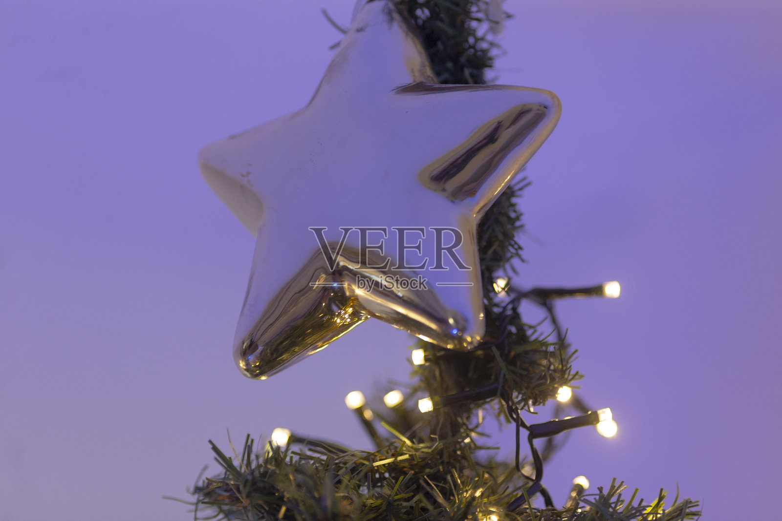 一颗闪亮的星星气球悬挂在装饰精美的树上照片摄影图片