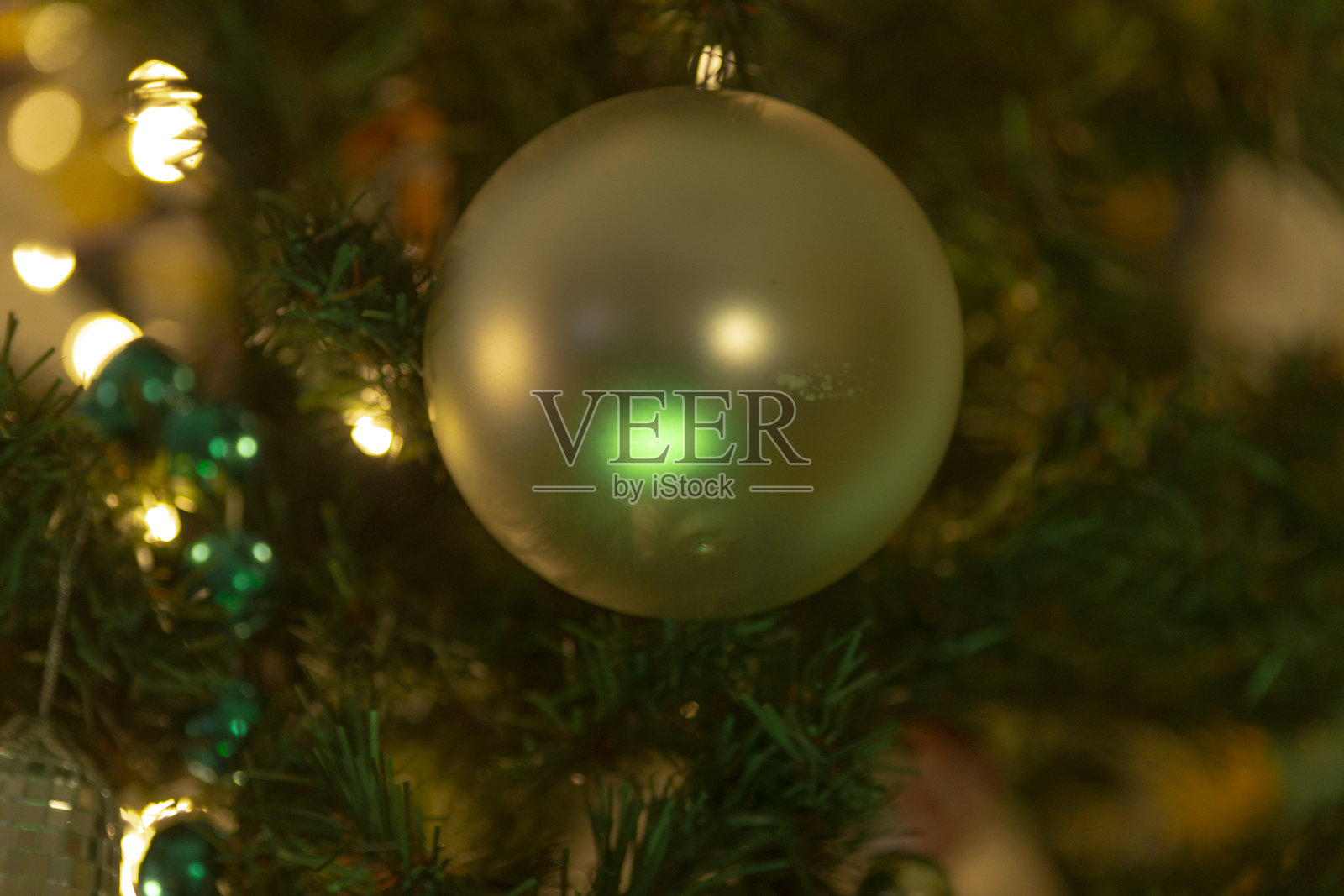 一棵装饰精美的圣诞树上挂着一个绿色的装饰球照片摄影图片