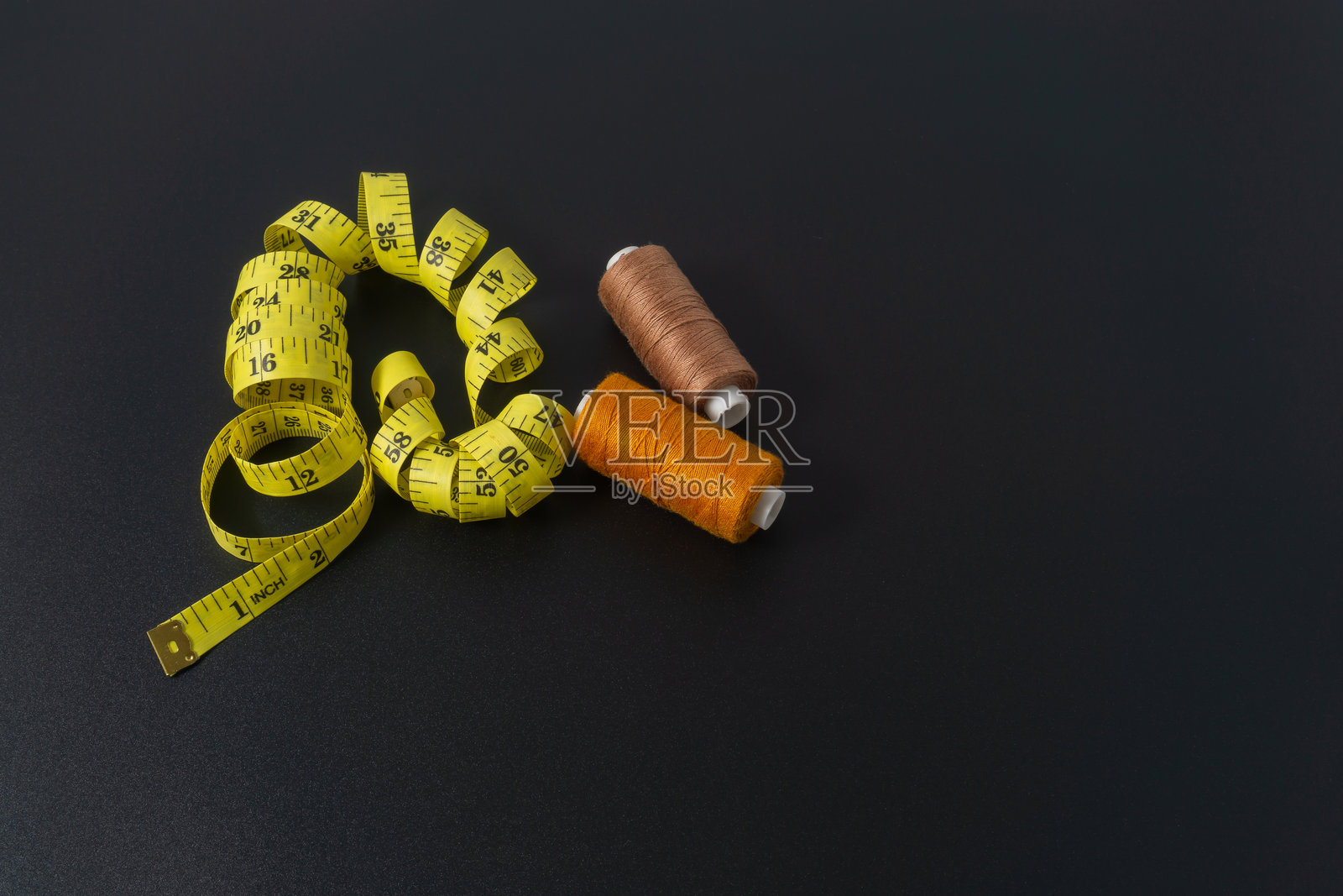 黑色背景上的涤纶缝纫线和裁缝带照片摄影图片