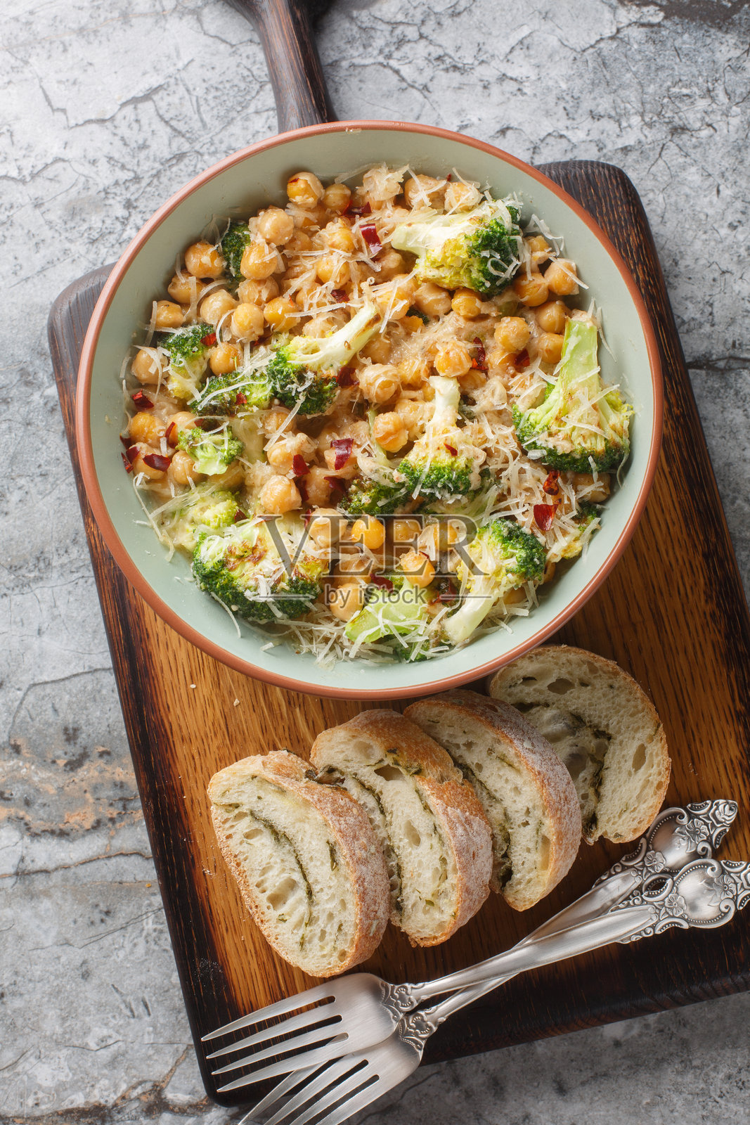 盘子里的鹰嘴豆西兰花阿尔弗雷多酱，撒上辣椒片和帕尔马干酪的特写。垂直俯视图。照片摄影图片