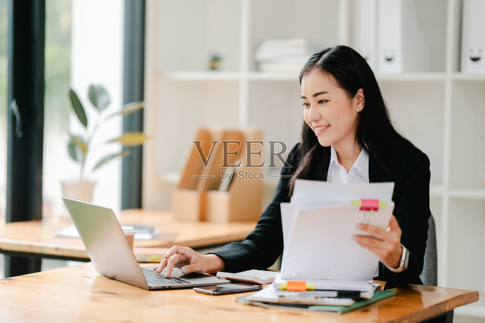 亚洲女商人在办公室工作，桌上有文件，计划分析财务报告、商业计划、投资和财务分析概念。照片摄影图片