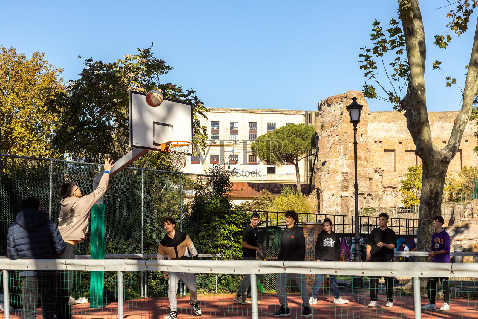 男孩们在罗马的科尔莱奥皮奥公园的篮球场上打篮球照片摄影图片