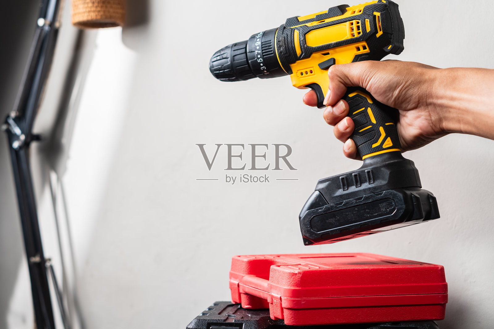 无绳电钻放在红色工具箱上方照片摄影图片