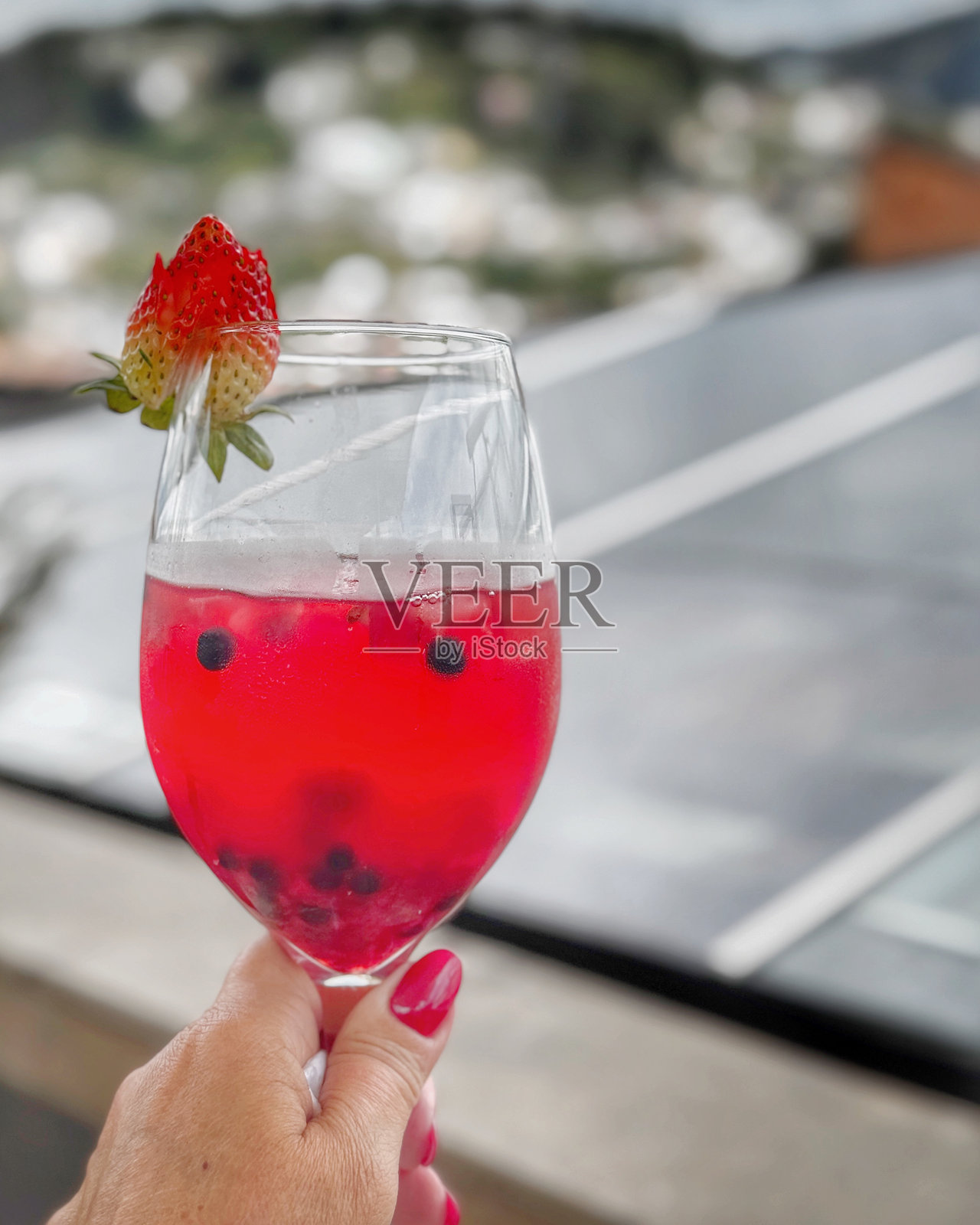 一杯用草莓装饰的红色鸡尾酒照片摄影图片