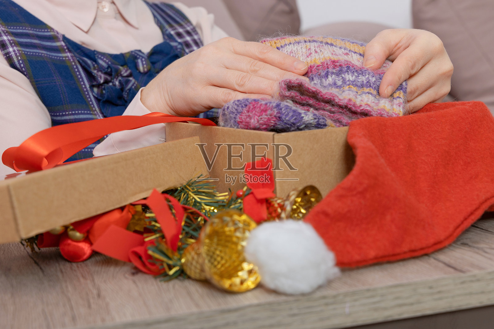 女人把圣诞毛线袜放进纸箱里照片摄影图片