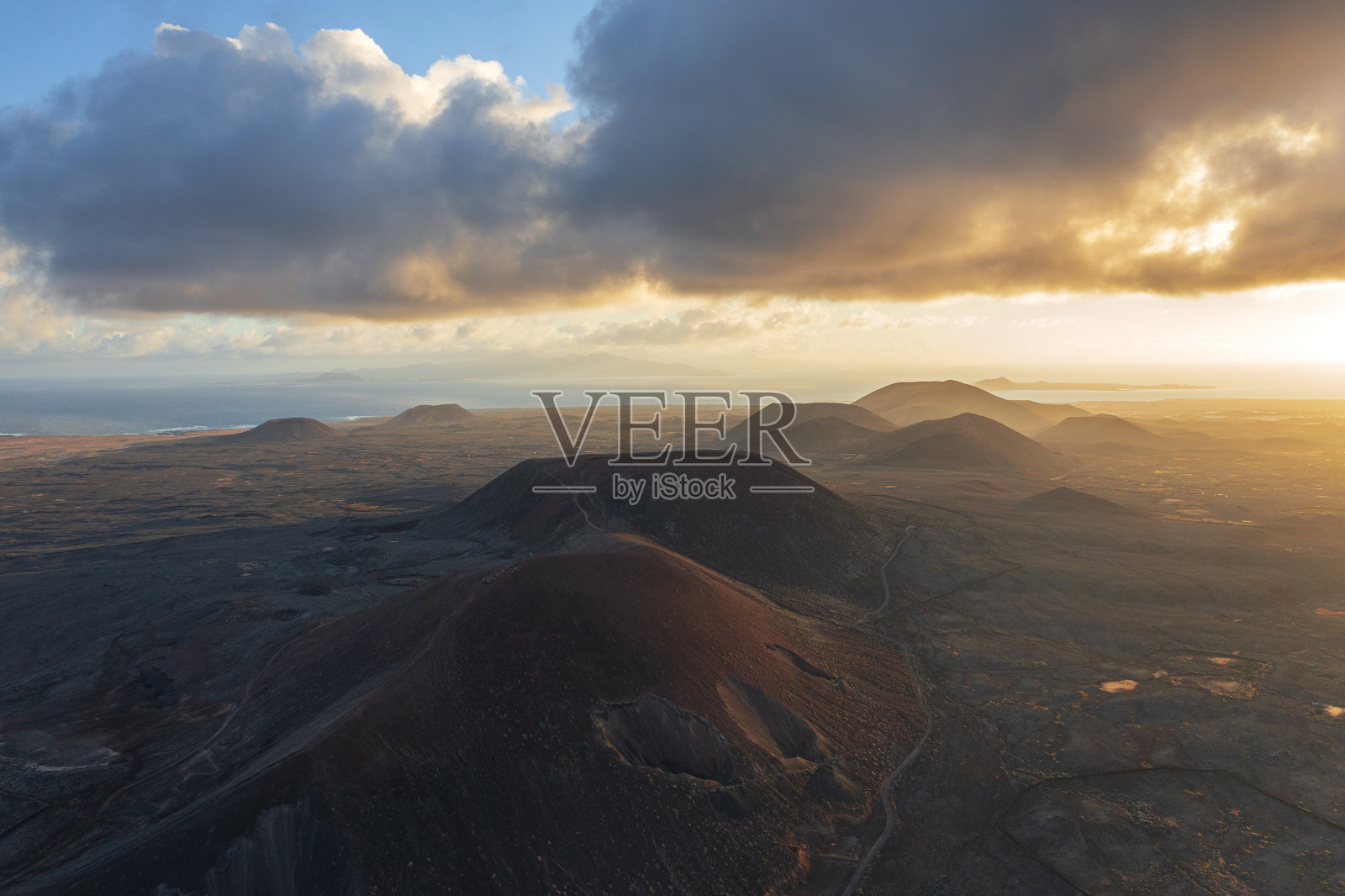 日出时分，福尔特文图拉的火山景观在雾霭中，鸟瞰图。照片摄影图片