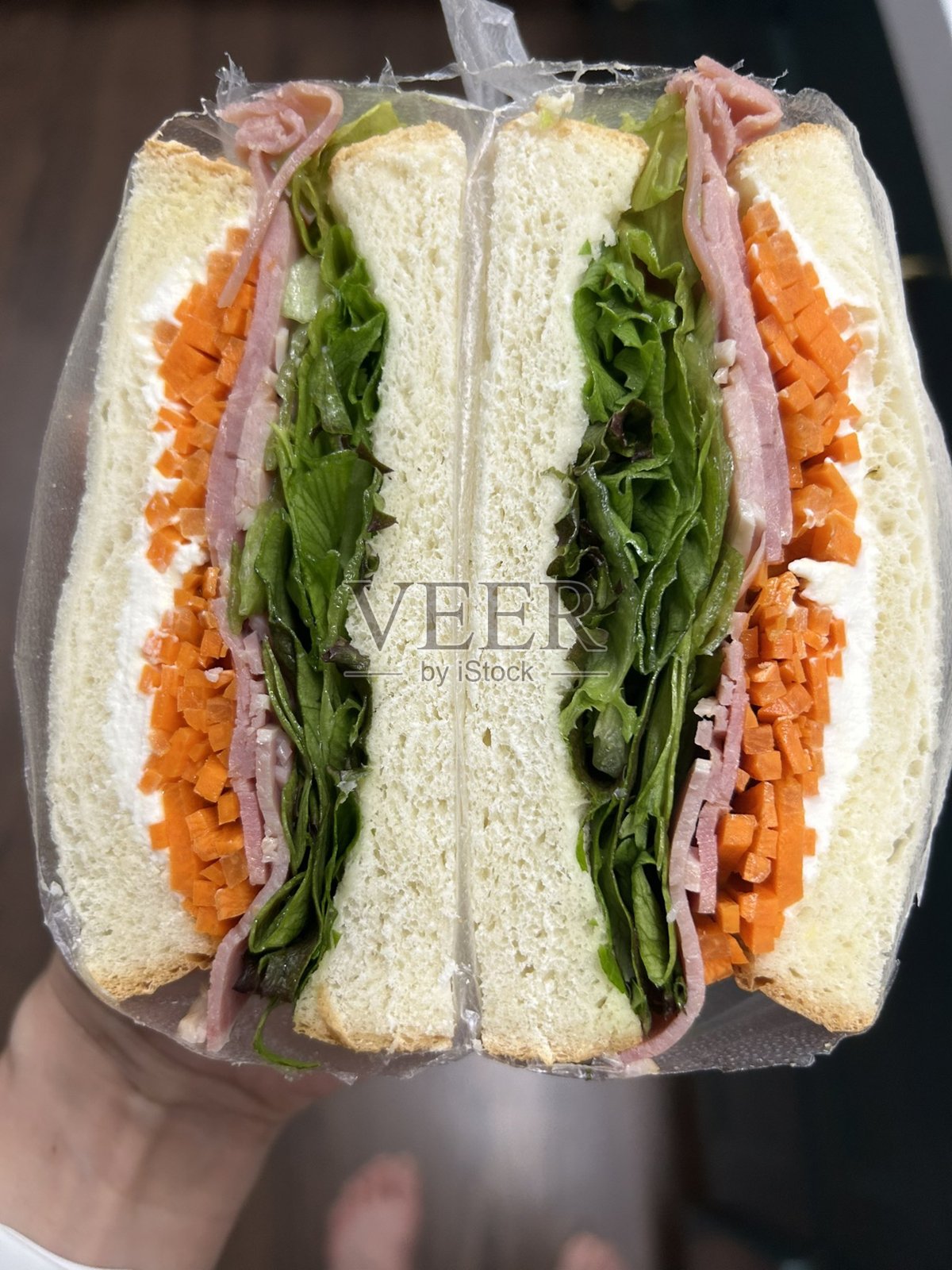 美味的三明治，夹满新鲜的食材，如脆嫩的蔬菜、鲜嫩的肉类和美味的酱料，夹在两片柔软的面包之间。非常适合快速而令人满意的餐点。照片摄影图片