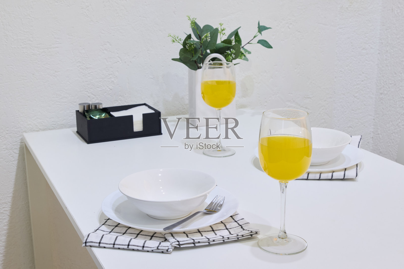 优雅的餐桌布置，搭配明亮的黄色饮品和新鲜的绿色装饰照片摄影图片