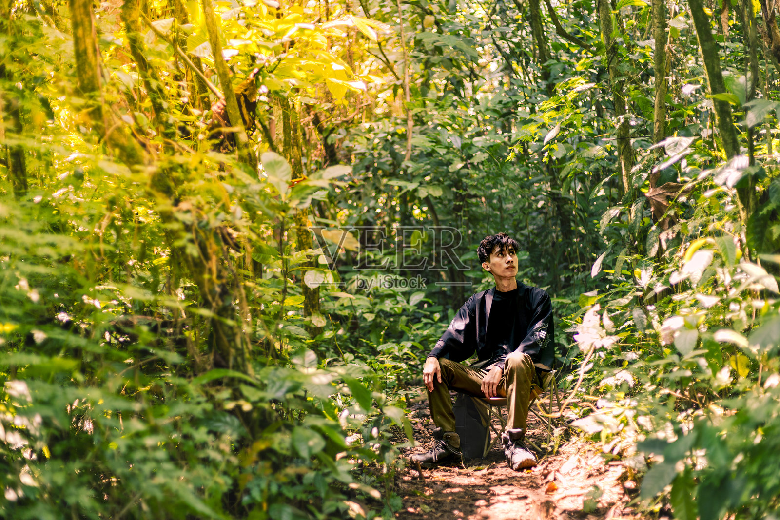 男人坐着享受大自然的美好。宁静的荒野：坐落在山中的宁静森林。照片摄影图片
