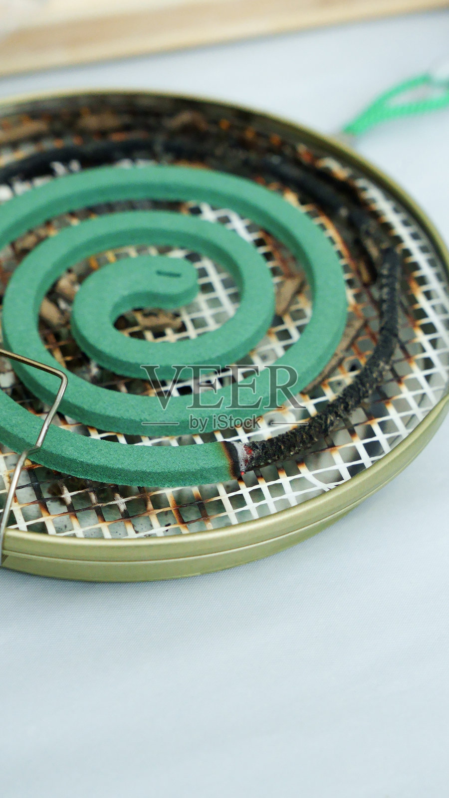 黑色背景上燃烧的绿色螺旋蚊香和红色火焰伴随白色烟雾。照片摄影图片