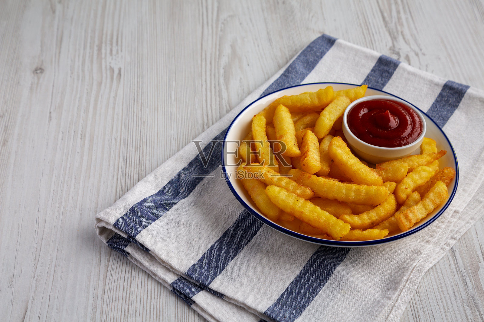 自制不健康的皱纹薯条配番茄酱，侧面视图。留白空间。照片摄影图片