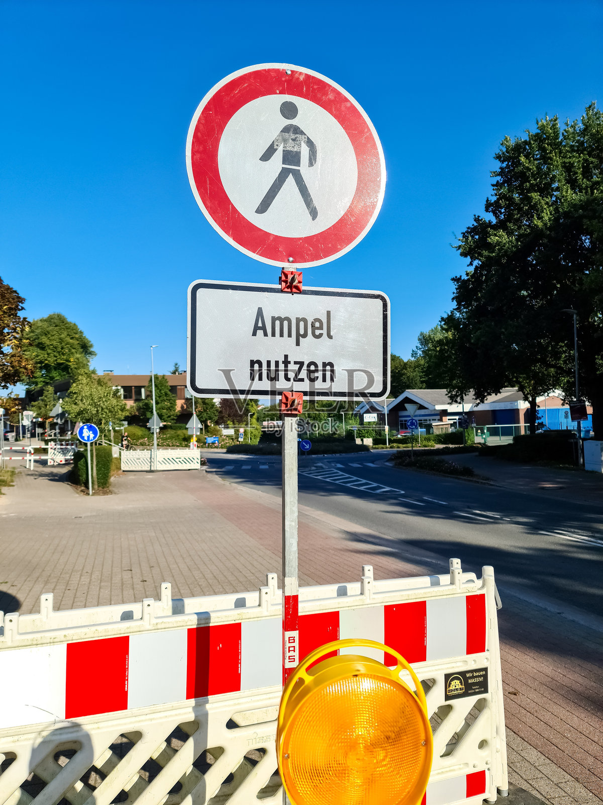 路上的障碍物，上面有德语的交通信号灯使用说明。照片摄影图片