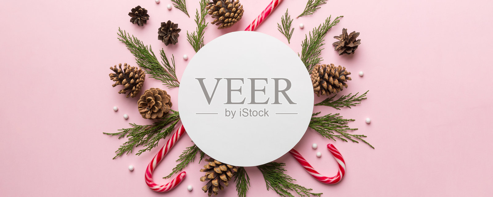 平铺的圣诞节构图。圆形纸张空白、松树枝、圣诞装饰品在彩色背景上。俯视图，留白供文本使用。照片摄影图片