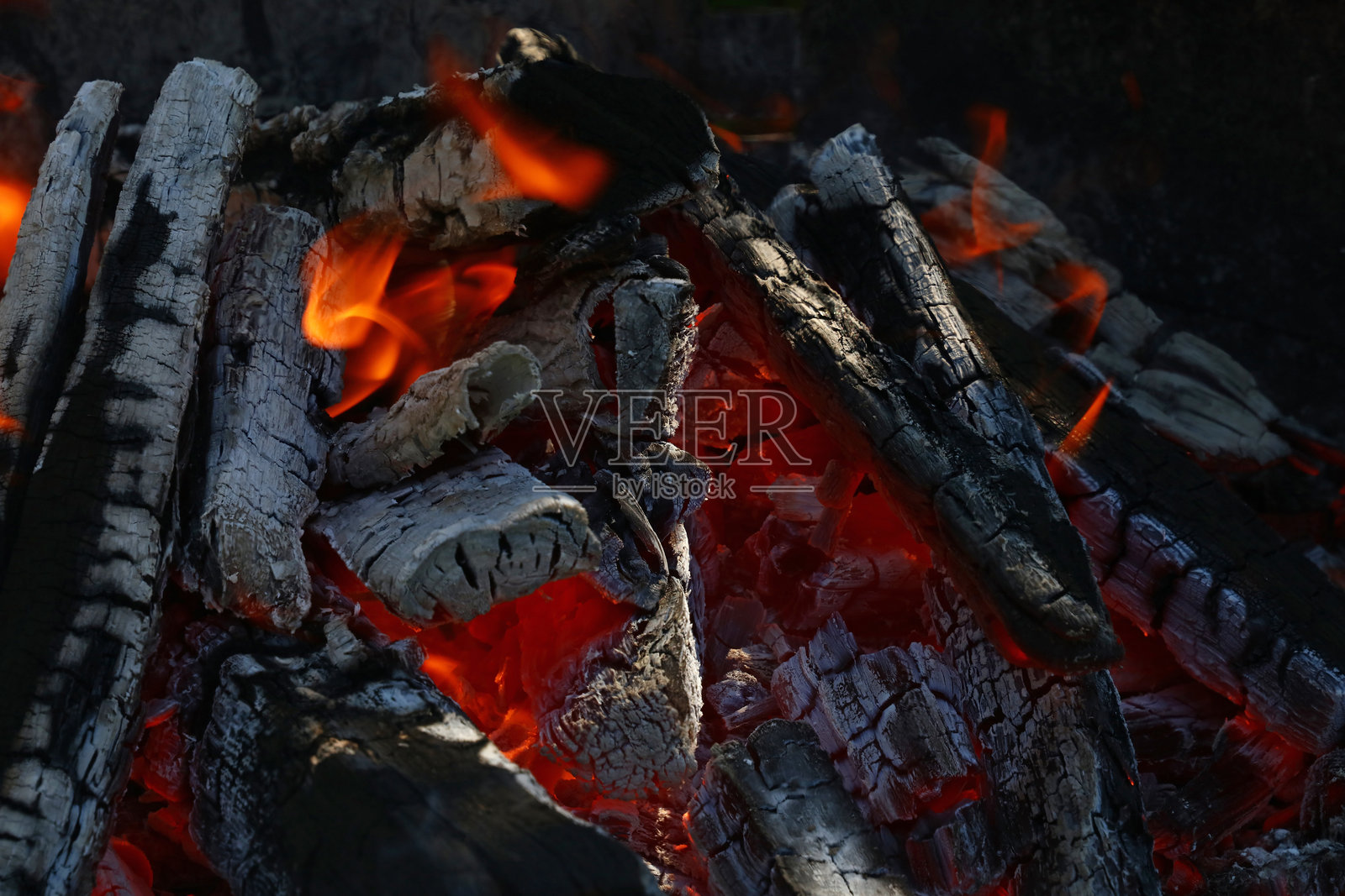 燃烧的木柴和炭火营造出温馨的篝火照片摄影图片