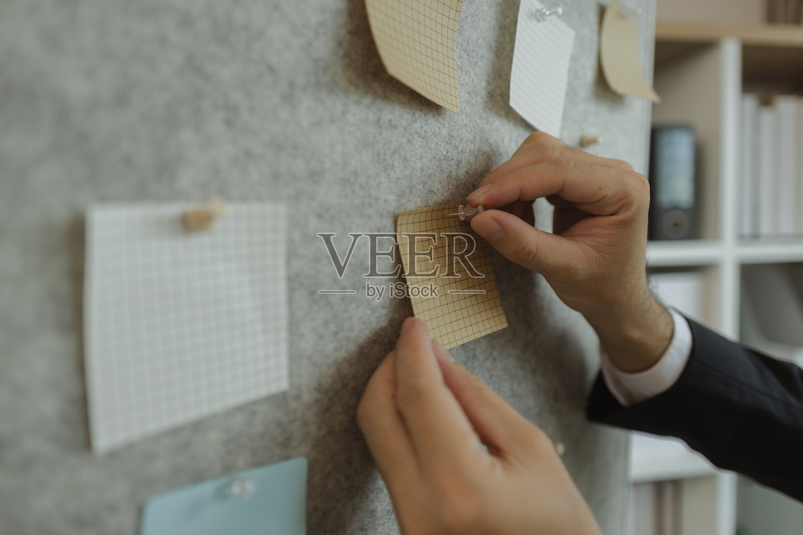 一位商人正在制定一个高效工作的策略，以对公司产生最积极的影响。一位公司的高管正在将想法整理成具体的形式，以便于理解。照片摄影图片