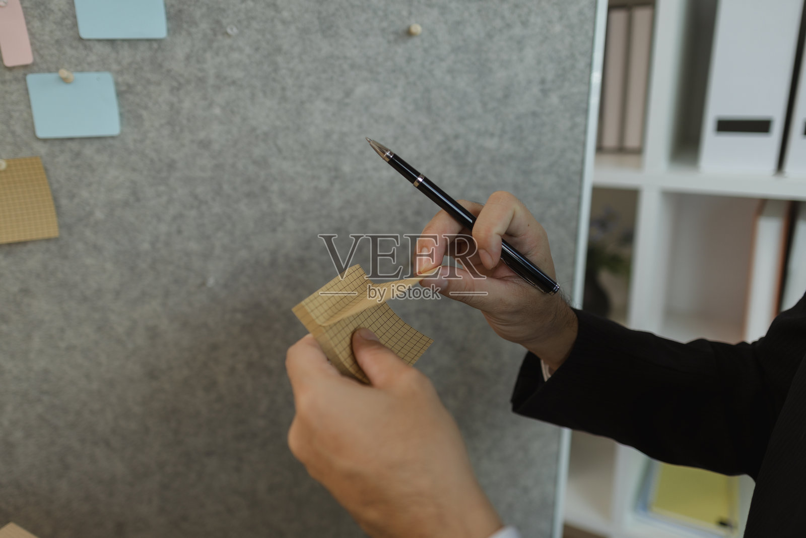 一位商人正在制定高效工作的策略，以对公司产生最积极的影响。一位公司的高管正在将想法整理成具体的形式，以便于理解。照片摄影图片