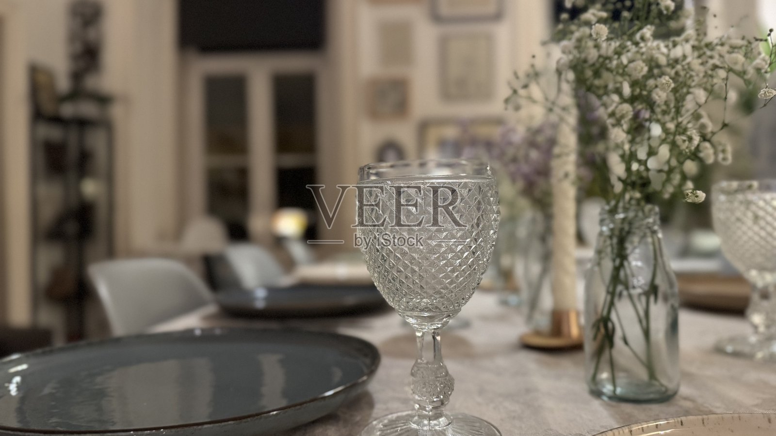 一张精美布置的餐桌，上面摆放着优雅的盘子、酒杯和新鲜花卉的中心装饰，展现出和谐而温馨的用餐氛围。照片摄影图片