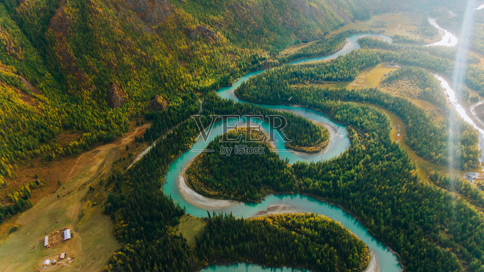 碧绿色的河流蜿蜒穿过山谷中的郁郁葱葱的森林照片摄影图片