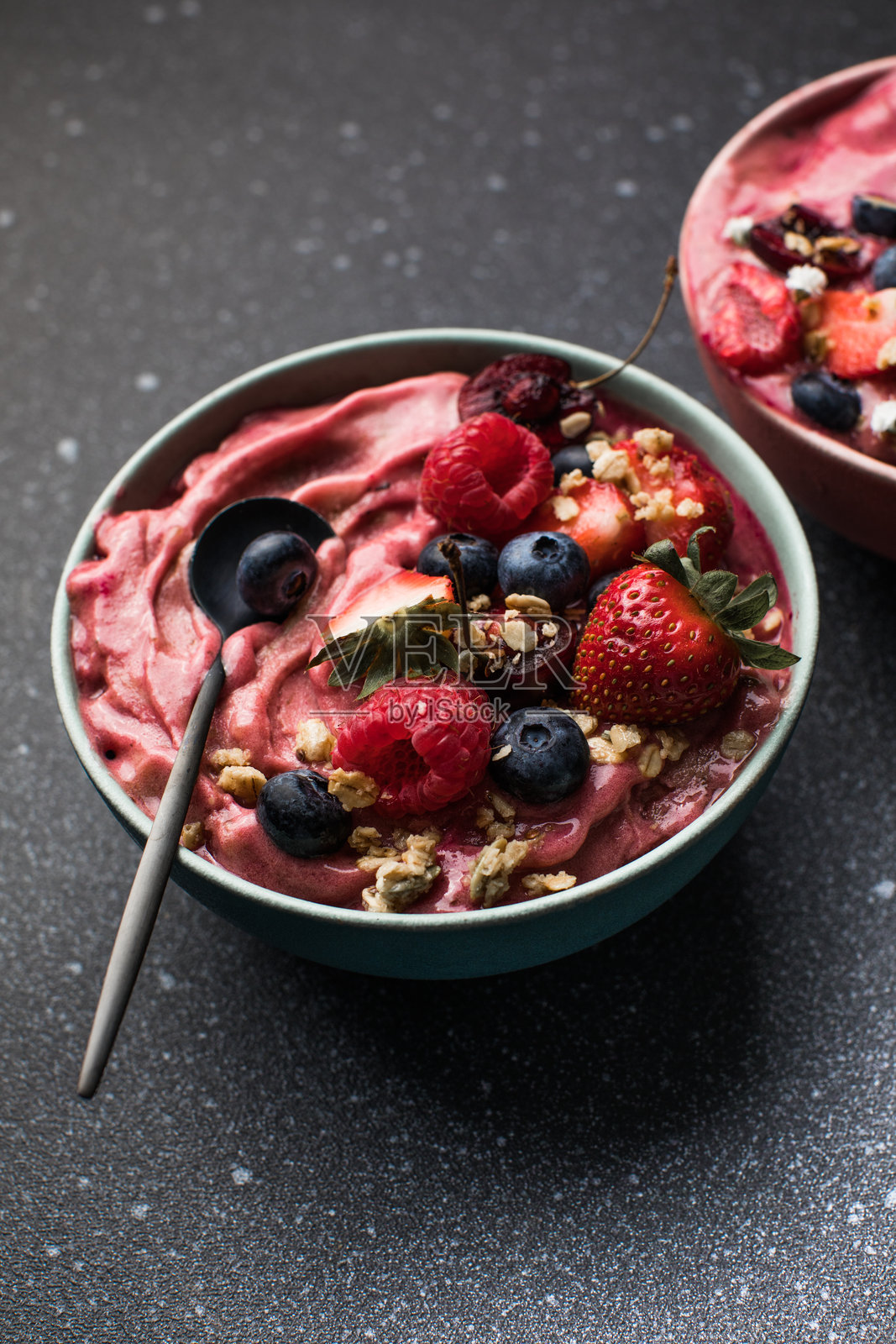 阿萨伊早餐超级食品冰沙碗，上面撒有蜂花粉、格兰诺拉麦片、椰子片和蓝莓。俯视视角平铺展示。照片摄影图片