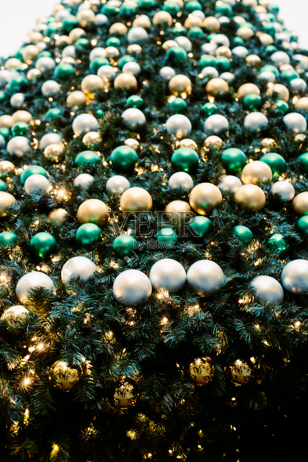 金色、绿色、银色和绿色的装饰品挂在圣诞树上照片摄影图片