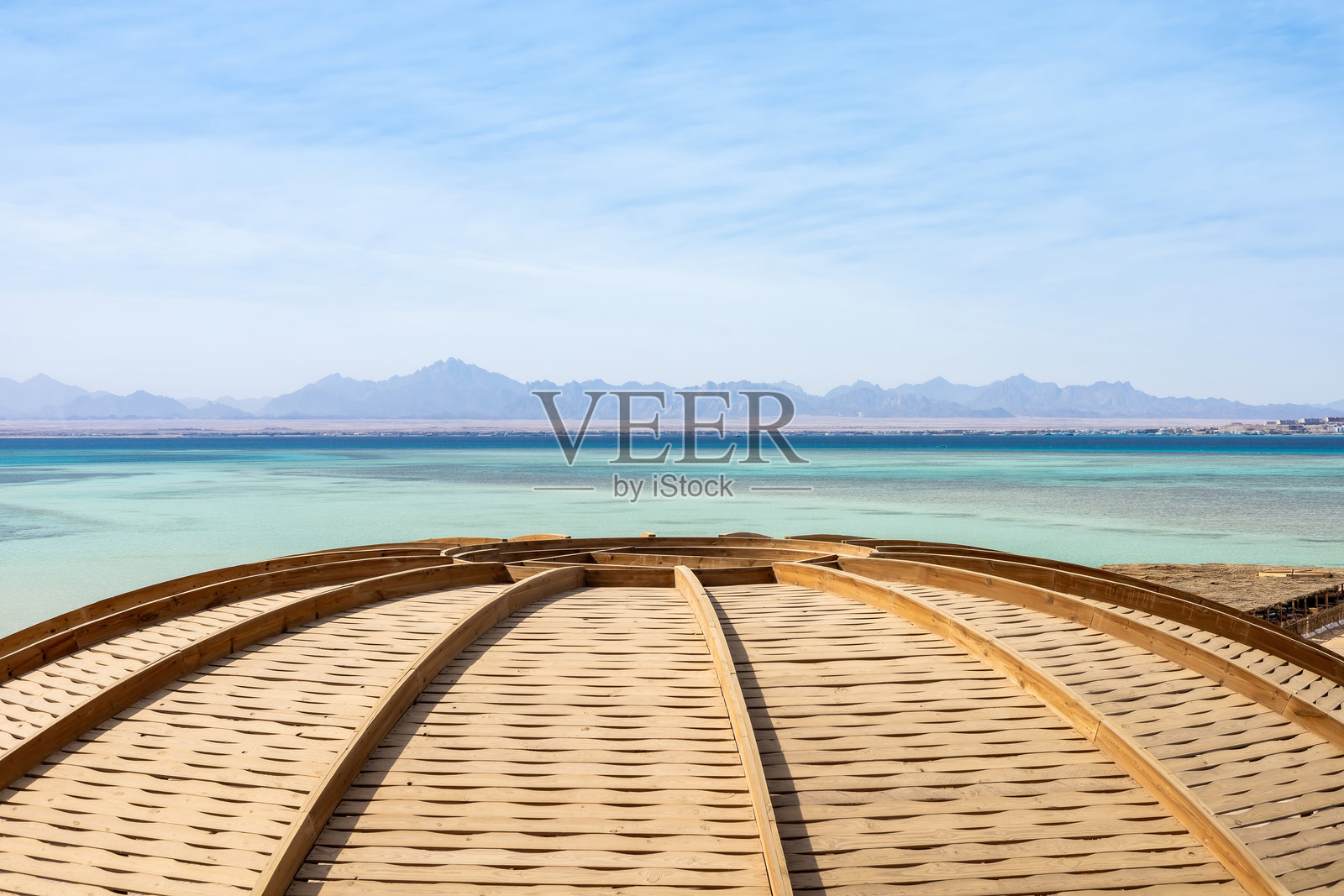 宁静的海岸景观，木质圆顶和远处的低分辨率山脉照片摄影图片