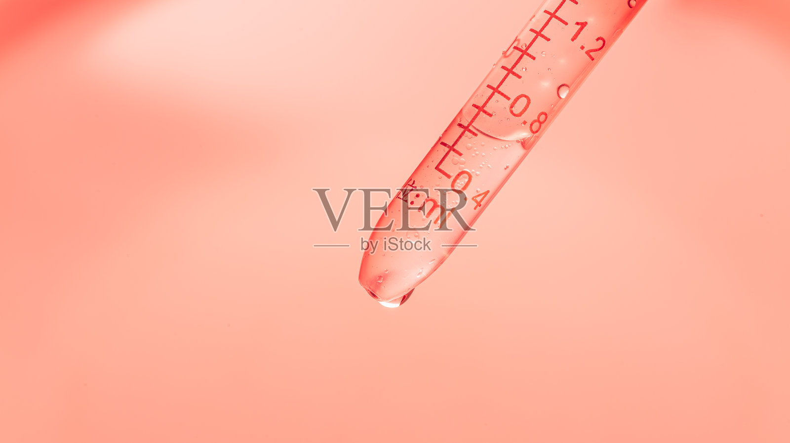 粉色科学试管特写，倾斜的试管内有透明液体和实验室滴管，背景为粉色渐变，抽象的身体护理化妆品配方概念照片摄影图片