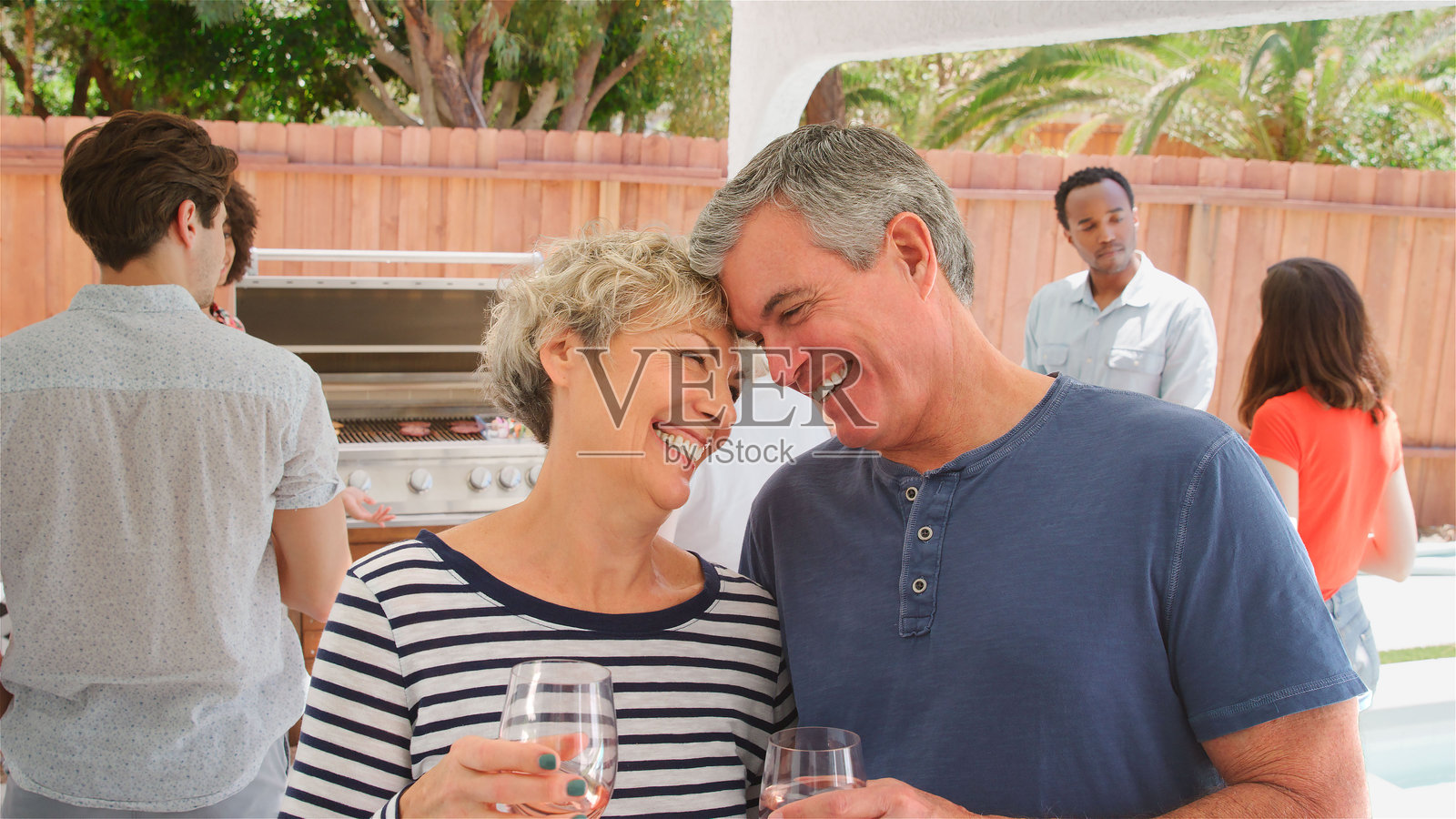 家庭聚会，老年父母与成年子女及朋友在户外的家中欢聚照片摄影图片