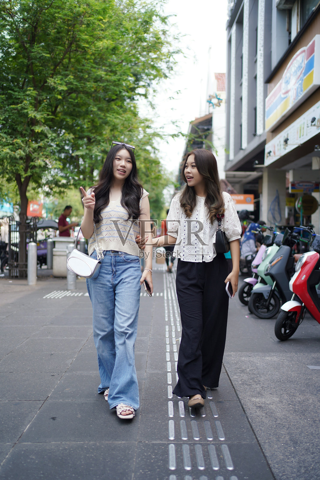 两位快乐的亚洲女性在街上散步照片摄影图片
