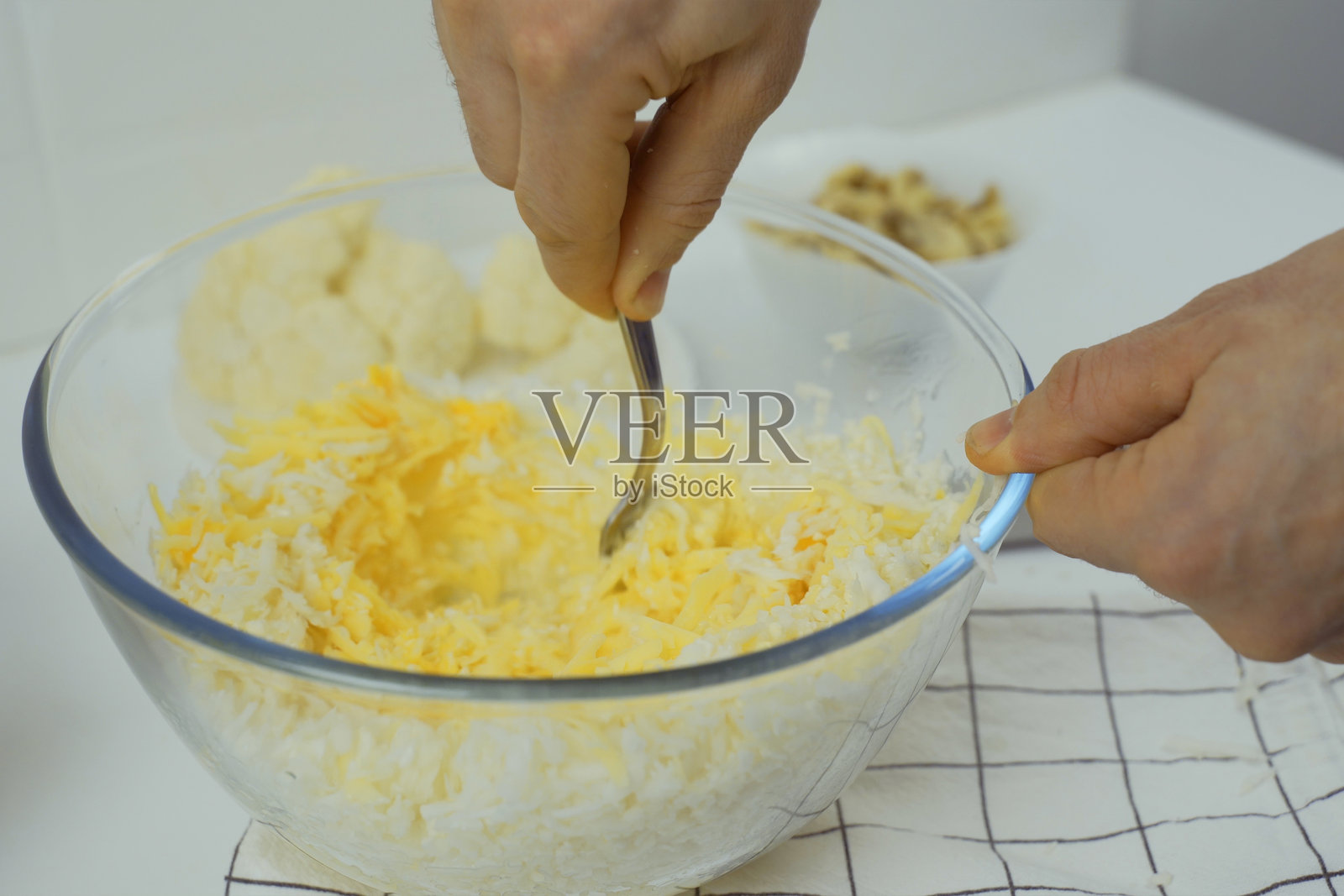 制作素食披萨，将配料混合在碗中。照片摄影图片