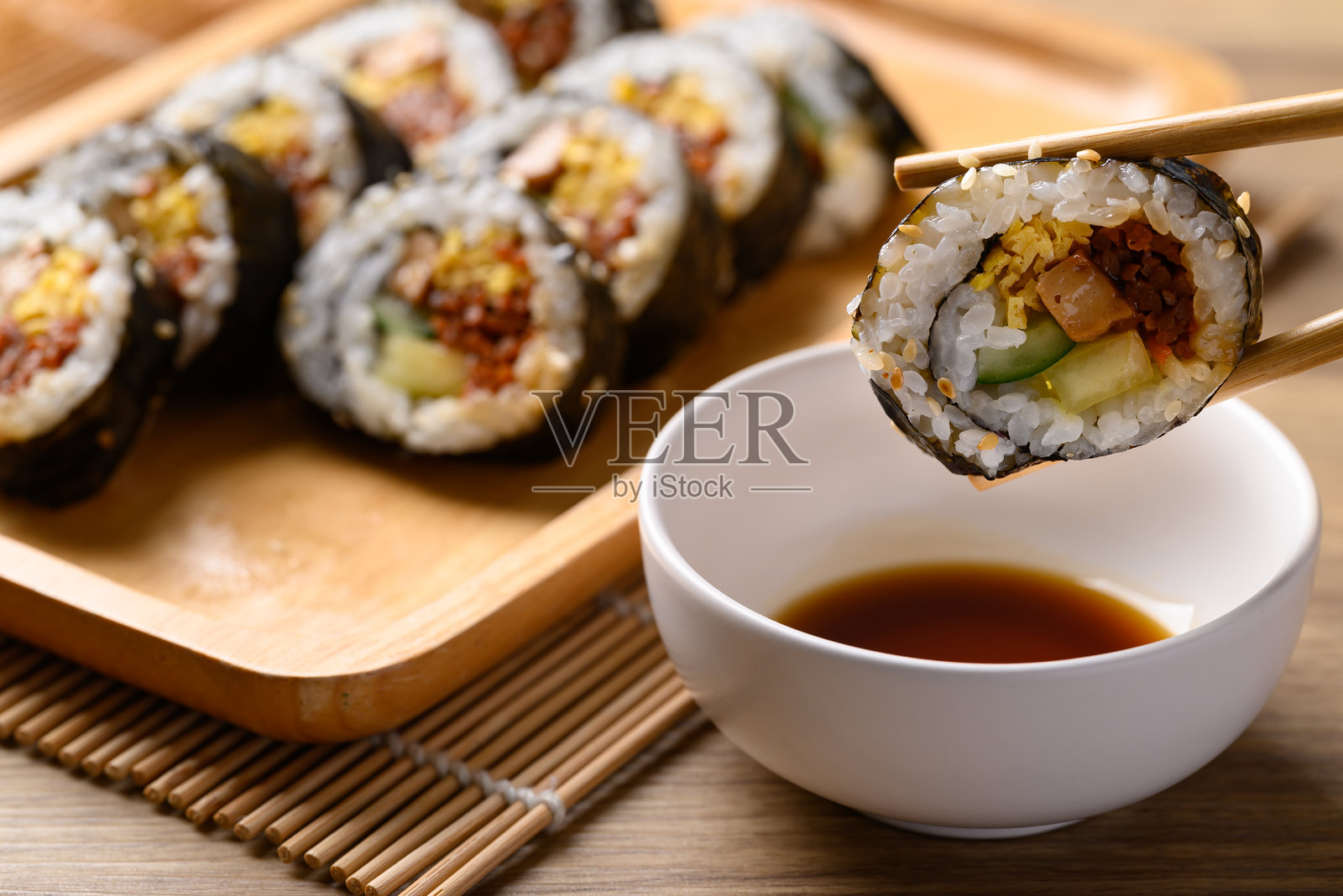 紫菜包饭，韩国美食，由熟米饭、蔬菜、肉类、鸡蛋制成，包裹在干海苔中，搭配酱汁食用。照片摄影图片