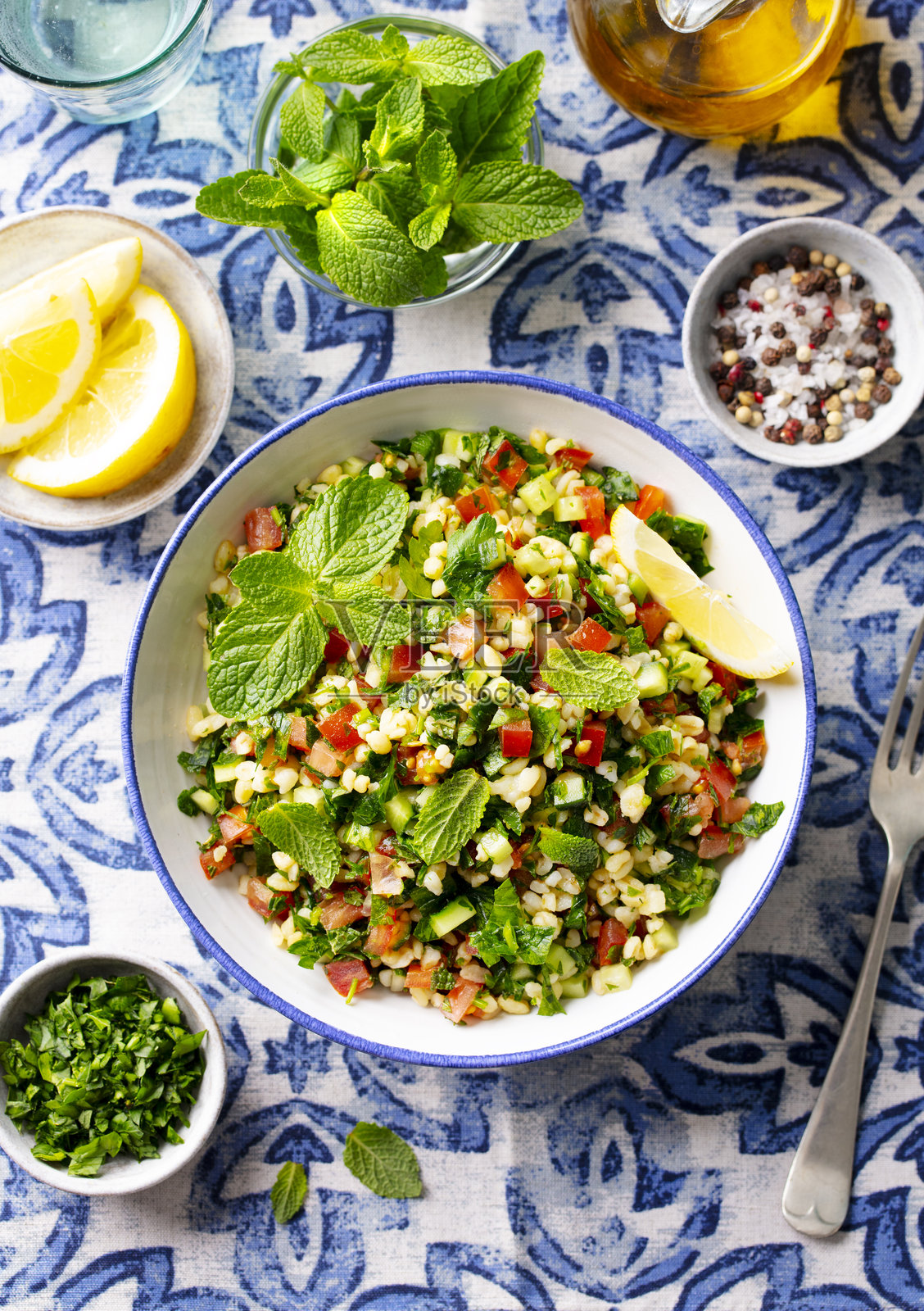 碗中的塔布勒沙拉。蓝色背景。特写。俯视图。照片摄影图片