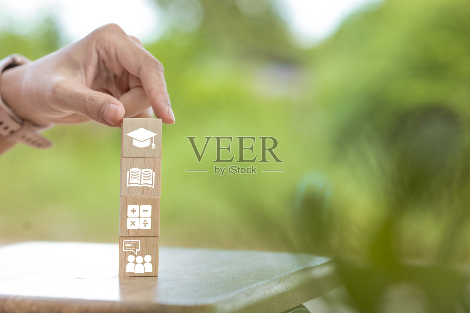 一只手在堆叠带有教育图标的木块照片摄影图片
