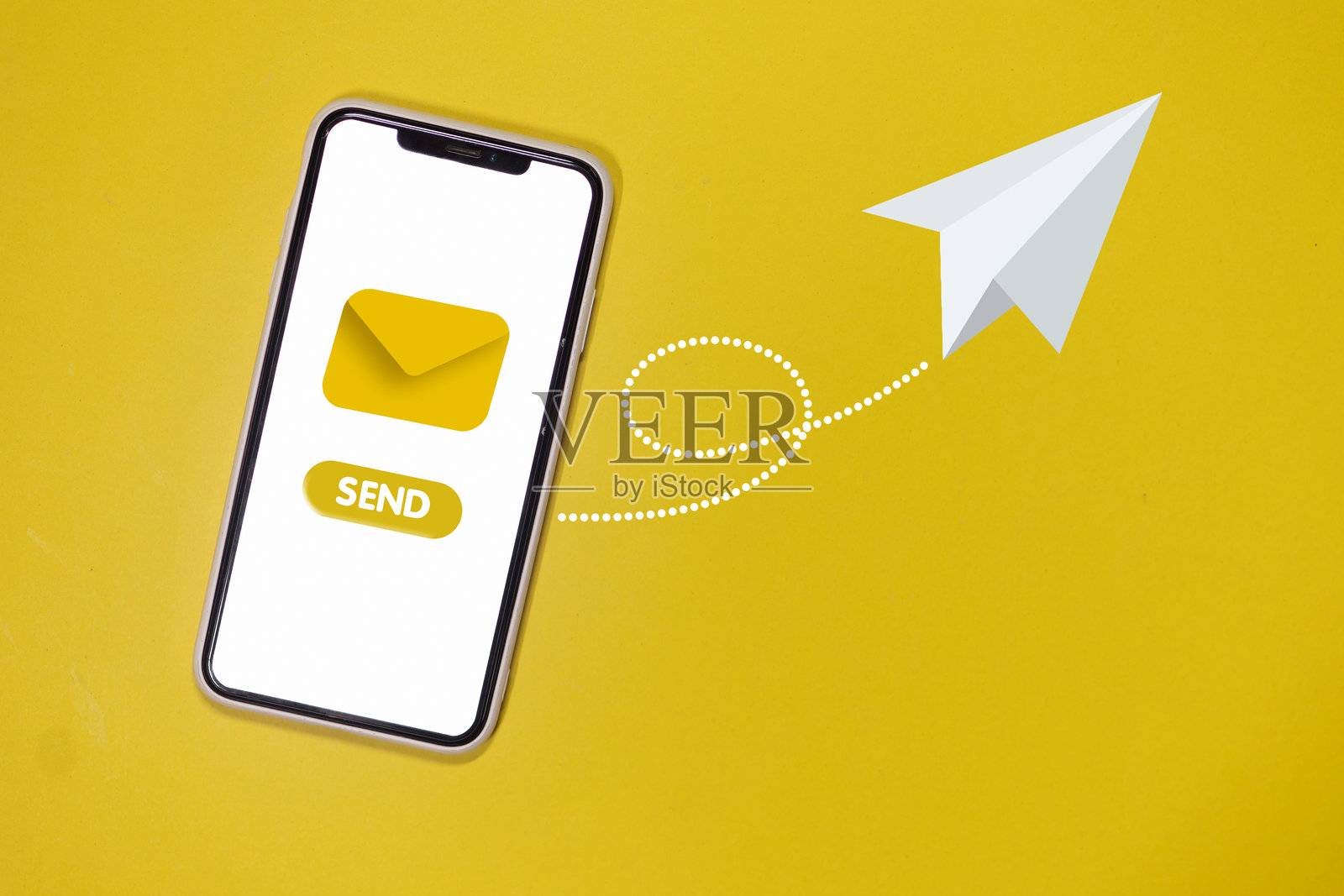 一部带有发送按钮的手机置于黄色背景上照片摄影图片